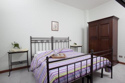 a bedroom with a bed and a wooden cabinet at Bed & Breakfast Conca Verde in Cavriana