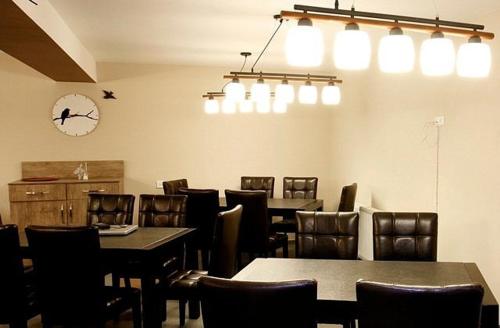 a dining room with tables and chairs and a clock at Hotel Abu in Gudauri