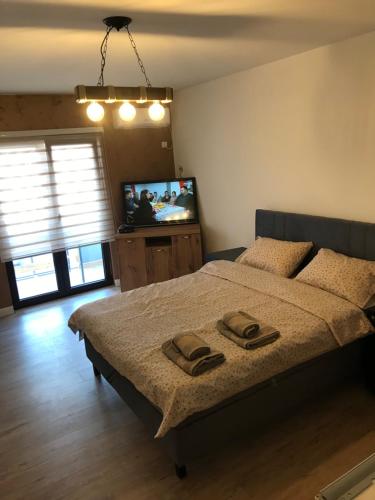 a bedroom with a bed with two towels on it at Apartman Ika 4N in Kraljevo