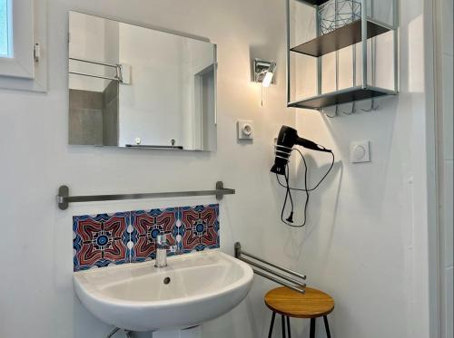 une salle de bain blanche avec un lavabo et un miroir dans l'établissement Le Quartier - 4 alleenstaande gites, à Banne