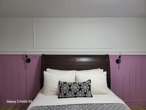 a bed with purple doors and a black and white pillow at Beau Séjour in Quebec City