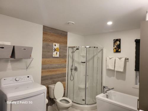 a bathroom with a shower and a toilet and a sink at Beau Séjour in Quebec City