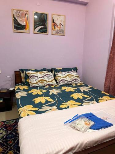 een slaapkamer met een bed met een blauwe en gele deken bij Centrally located, big home in Calcutta