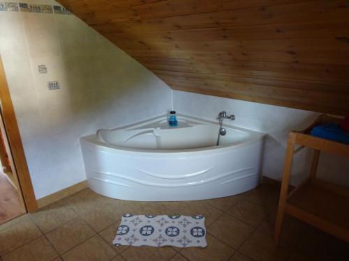 bañera blanca en una habitación con techo de madera en Charmant chalet du Kohlberg, en Dabo