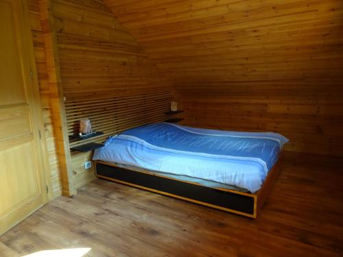a bedroom with a bed in a wooden cabin at Charmant chalet du Kohlberg in Dabo