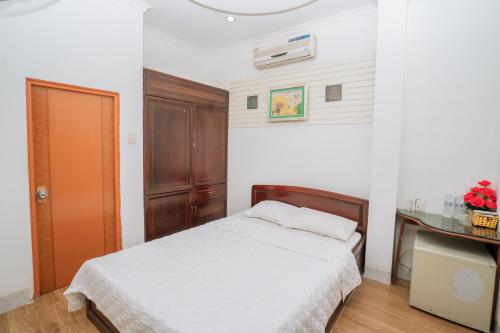a small bedroom with a bed and a glass table at Triệu Vũ Hotel & Apartment in Buon Ma Thuot