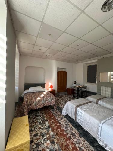 Habitación de hotel con 2 camas y mesa en B&B Orchidea Bianca, en Gattico
