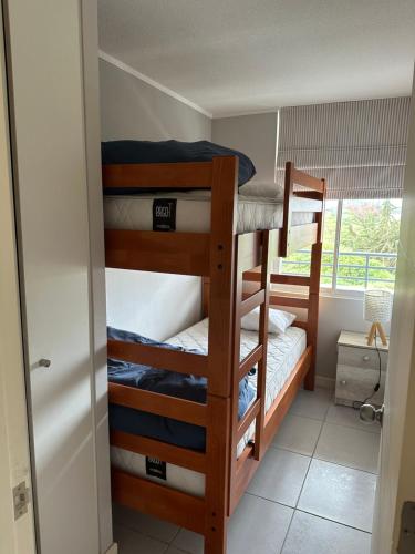 two bunk beds in a room with a window at Full equipado frente al mar 4307 in Los Molles