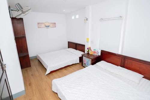 a bedroom with two beds and a window at Triệu Vũ Hotel & Apartment in Buon Ma Thuot