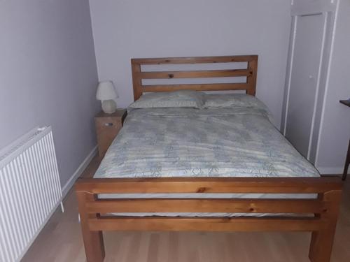 a bed in a bedroom with a wooden bed frame at Robs Place, Liverpool in Liverpool