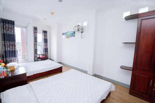 a bedroom with two beds and a window at Triệu Vũ Hotel & Apartment in Buon Ma Thuot