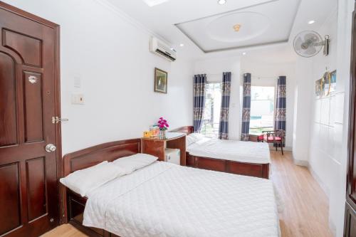 1 dormitorio con 2 camas y mesa en Triệu Vũ Hotel & Apartment, en Buon Ma Thuot