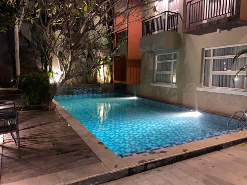 a swimming pool in front of a building at Regato Suites in Jakarta