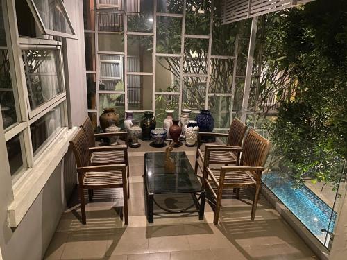a patio with a glass table and chairs and windows at Regato Suites in Jakarta