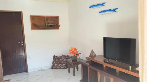 uma sala de estar com uma televisão de ecrã plano sobre uma mesa em Suite Baia dos Corais em Angra dos Reis