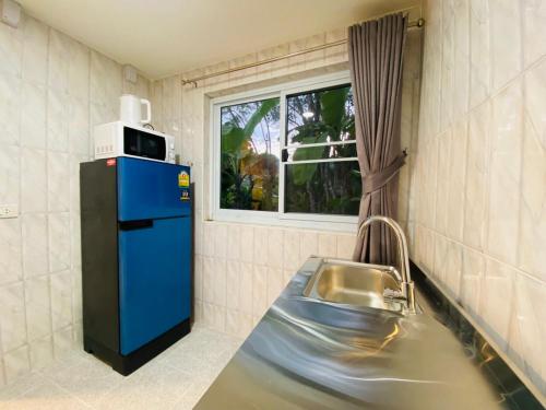 uma cozinha com um frigorífico azul e um lavatório em SLAV Naithon Boutique Hotel and Restaurant em Phuket