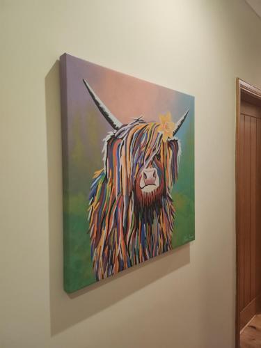 a painting of a yak hanging on a wall at Auchendennan Farm Self Catering Cottages in Balloch