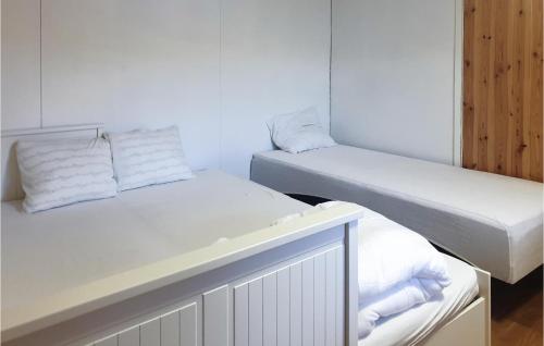 two beds in a white room with towels at 1 Bedroom Gorgeous Home In Torsby in Branäs