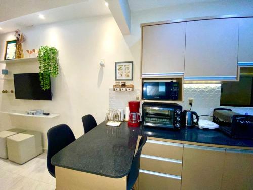 a kitchen with a counter top with a microwave at Apartamento RR Agradable y Moderno c 2 dormitorios y estacionamiento interno techado in Ciudad del Este