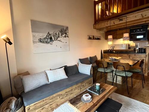 una sala de estar con un sofá y una mesa en Appartement ensoleillé aux Tines, vue Massif, en Chamonix-Mont-Blanc