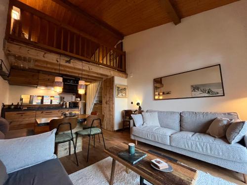 a living room with a couch and a table at Appartement ensoleillé aux Tines, vue Massif in Chamonix-Mont-Blanc
