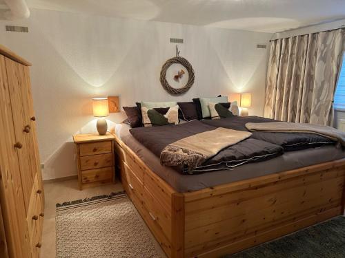 - une chambre avec un grand lit en bois et 2 lampes dans l'établissement Haus Leni am Paulsberg, à Braunlage