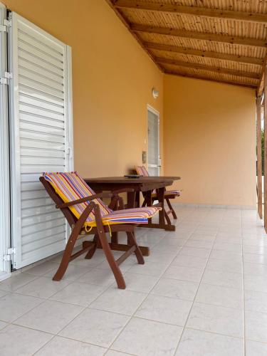 un patio con una mesa de madera y un banco en Thalassa Hideaway, en Dhiminión