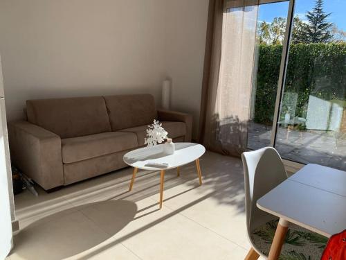 sala de estar con sofá y mesa en Maisonnette dans belle résidence, en Saint-Vallier-de-Thiey