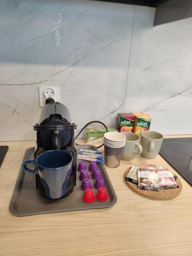 a coffee maker sitting on top of a counter next to cups at Apartament Prezydencki na Letniej 71m2 z Ogrodem i Widokiem na Góry Kłodzko - Przyjaciół Ziemi Kłodzkiej in Kłodzko