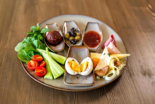 um prato de alimentos com ovos e legumes sobre uma mesa em The Külsümz Hotel em Istambul
