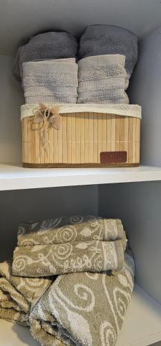 - une étagère avec des serviettes et une boîte de serviettes dans l'établissement Cozy apartment - 2 bedrooms in the best city area., à Ferizaj