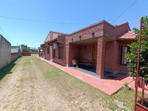 a brick house on a dirt road at Doña Ines in General Acha