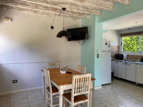 a kitchen with a table and chairs and a refrigerator at BOG Las Frutillas in Villa La Angostura