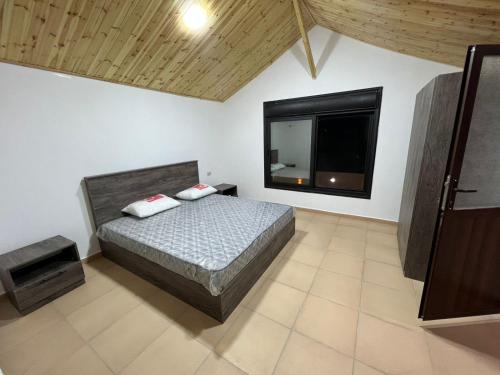 um quarto com uma cama e uma televisão de ecrã plano em Gernath farm em Ajloun
