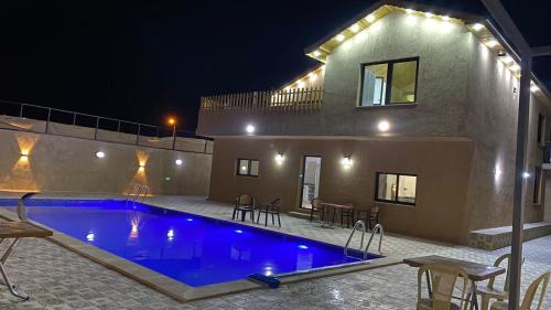 a swimming pool in front of a house at night at Gernath farm in Ajloun
