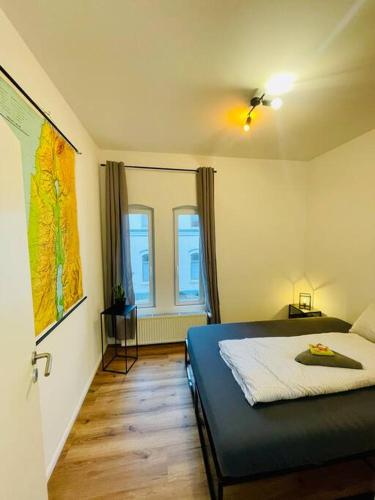 a bedroom with a bed and two windows at Zentrales Apartment mit großer Terrasse in Braunschweig