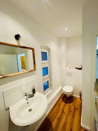 a white bathroom with a sink and a toilet at Zentrales Apartment mit großer Terrasse in Braunschweig