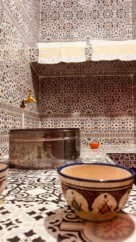 La salle de bains est pourvue d'un bol sur le sol carrelé. dans l'établissement NALU guest house, à Safi