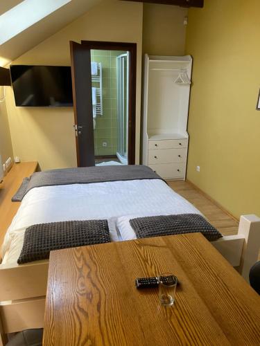 1 dormitorio con cama y mesa de madera en Akmenine Kerpe, en Marijampolė