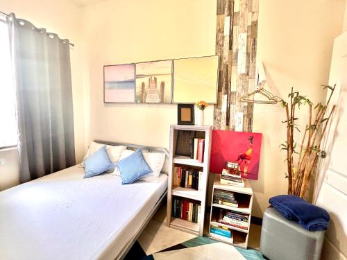 a small bedroom with a bed and a book shelf at Tomas Morato Quezon City - Residences in Manila