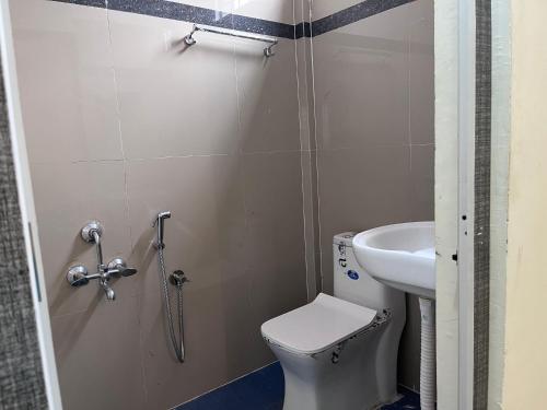 La petite salle de bains est pourvue de toilettes et d'un lavabo. dans l'établissement RR Stayinn, à Bangalore