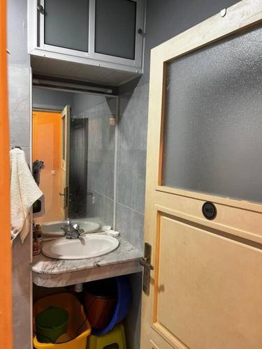 ein Badezimmer mit einem Waschbecken, einem Spiegel und einer Tür in der Unterkunft Agadir Morocco Furnished apartment for long-term rental in Agadir