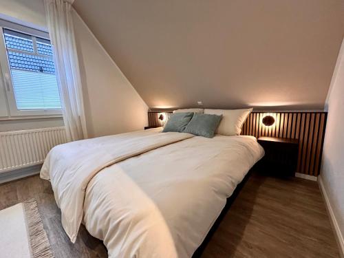 a large white bed in a room with a window at Ferienwohnung Frau Rogge in Bad Zwischenahn