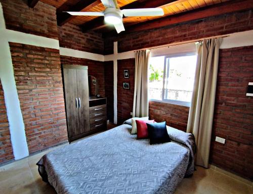 ein Schlafzimmer mit einem Bett und einem Deckenventilator in der Unterkunft Departamento Olmos in Mina Clavero