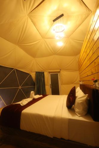 コダイカナルにあるKanal Glamp Kodaikanal Luxuriesのテント内の大型ベッド付きのベッドルーム1室