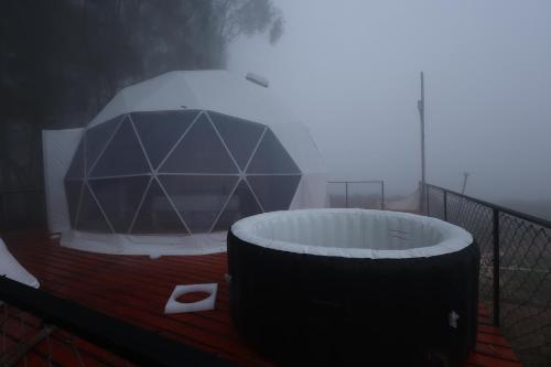 a hot tub on a balcony in the fog at Kanal Glamp Kodaikanal Luxuries in Kodaikānāl