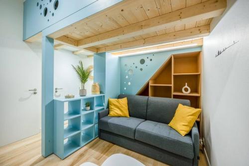 - un salon avec un canapé bleu et des étagères dans l'établissement Charmant appartement à deux pas du Vieux-Port, à La Rochelle