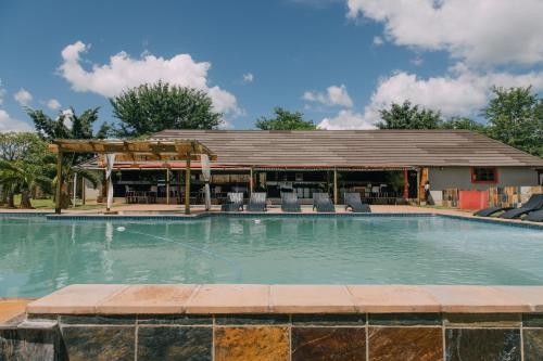 a swimming pool at a resort with a pavilion at Kruger View Chalets in Malelane