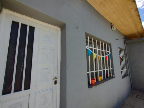 a white door with a window and some flags at Casita Festiva in Santa María