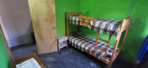 a room with two bunk beds in a green wall at Casita Festiva in Santa María